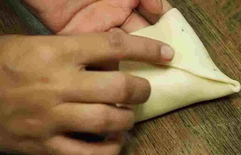 Cutting and folding into samosa shapes